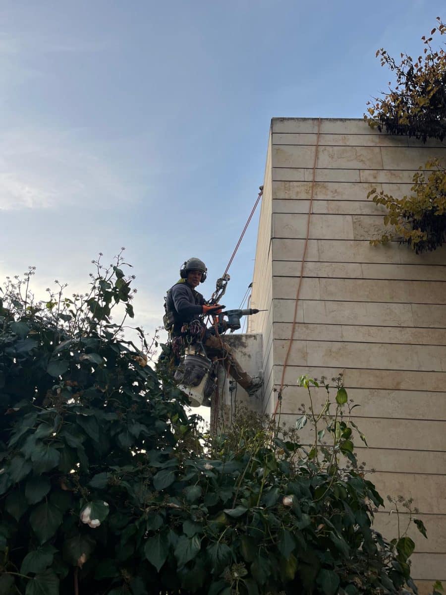 איש בסנפלינג על בניין מחזק אריחים